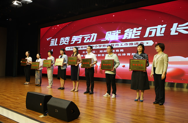郑州市教育局党组书记、局长王丽娟为获得首批郑州市中小学劳动教育特色学校代表颁奖.jpg