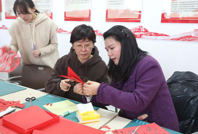 二七区春晖小学美术老师指导局机关干部职工剪窗花技巧方法.jpg